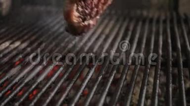 在烧烤上煎牛排。 典型的阿根廷烧烤或阿萨多。 烧烤架里的木头和红色的热煤。